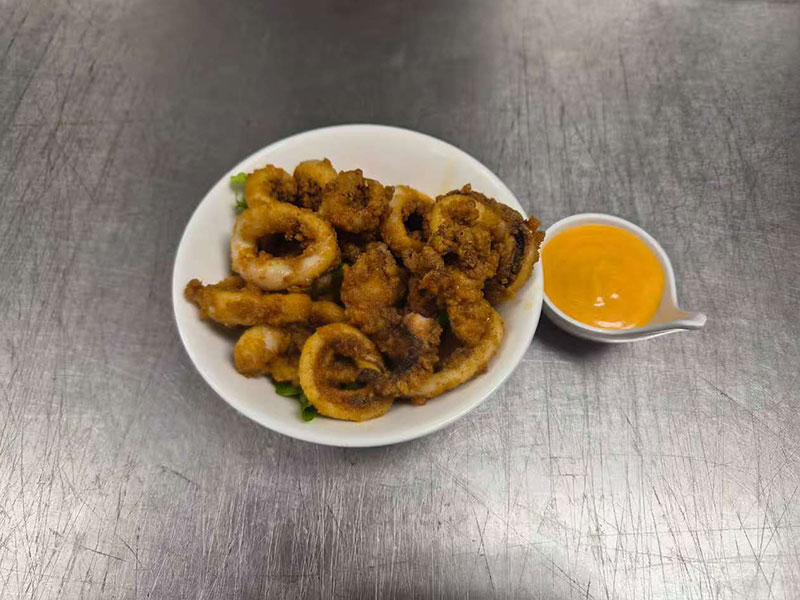 Golden fried calamari rings paired with creamy orange dipping sauce at Sushi & Grill, a Asian Restaurant in Elkton