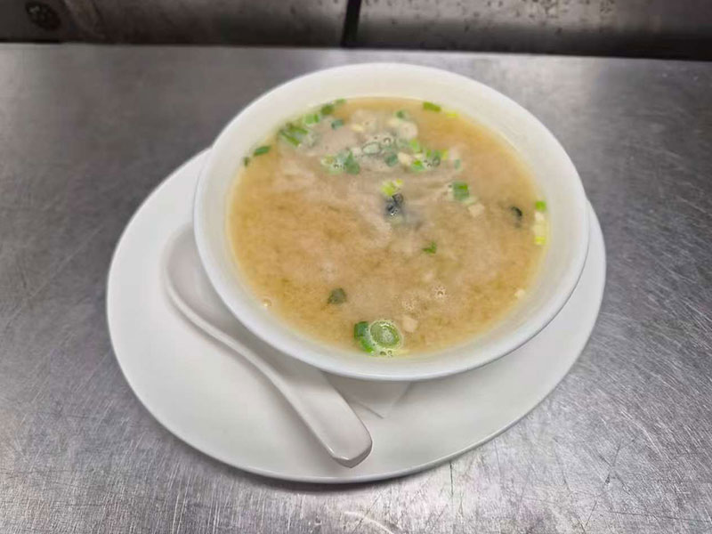 Warm bowl of egg drop soup garnished with chopped green onions at Sushi & Grill, a Asian Restaurant in Elkton