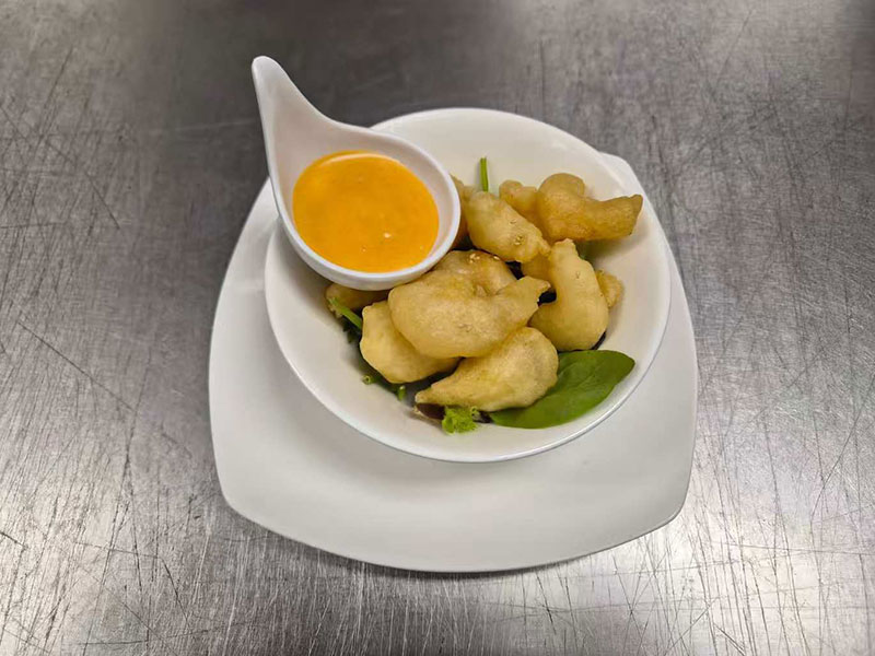 Bowl of light tempura shrimp served with orange dipping sauce at New Asian & Sushi Bistro, a Asian Restaurant in Elkton