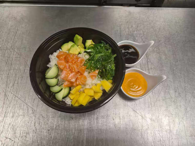 Fresh salmon poke bowl with mango, avocado, cucumber and side sauces at New Asian & Sushi Bistro, a Asian Restaurant in Elkton