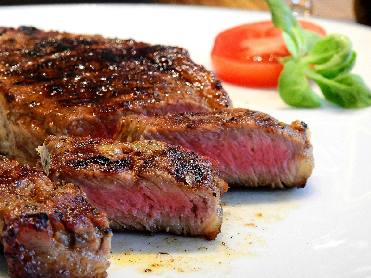 Grilled medium-rare steak garnished with tomato and basil at Sushi Kai, a Japanese Restaurant in Tallahassee