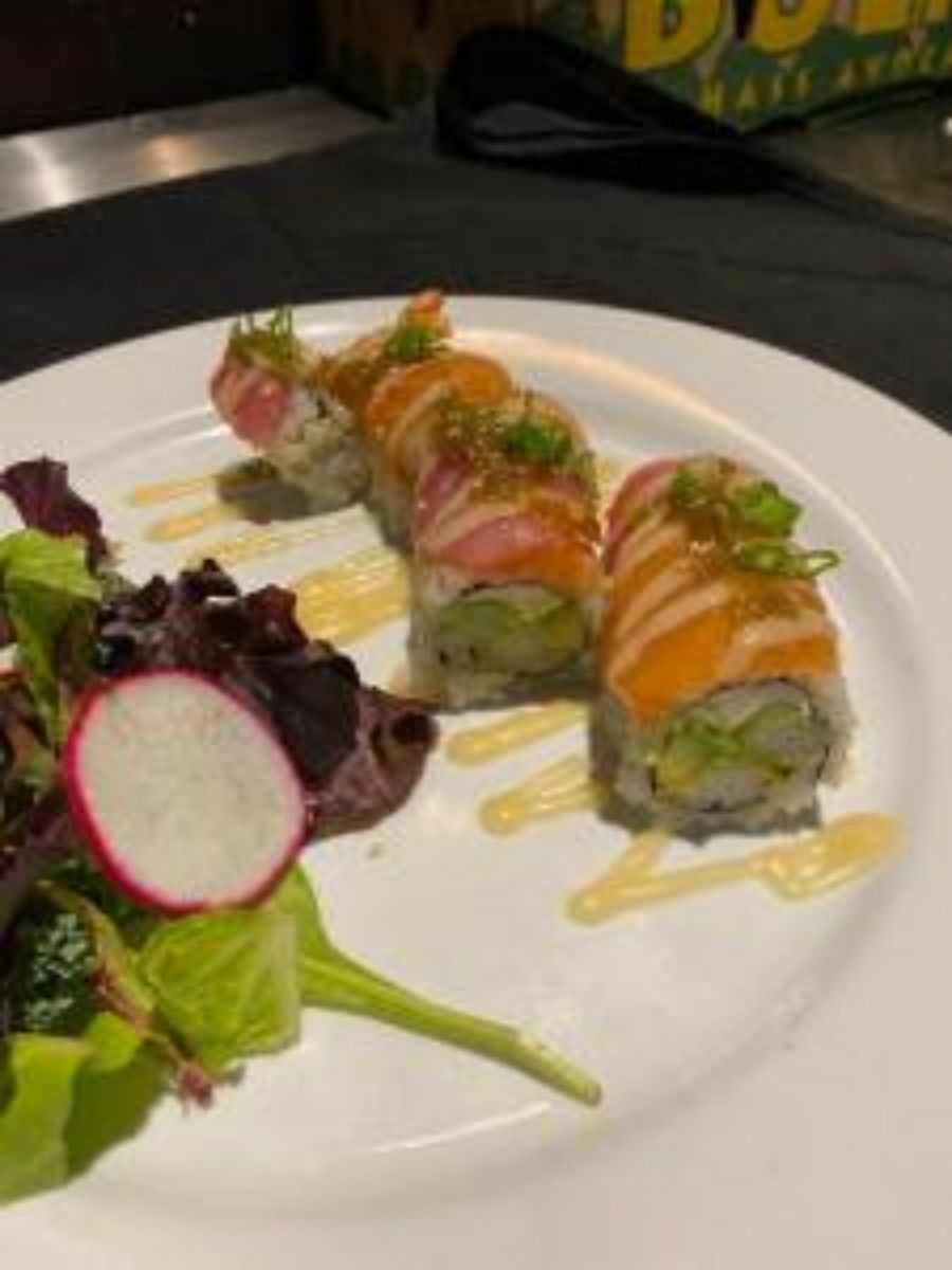 Salmon sushi rolls with mixed greens salad and drizzle sauce