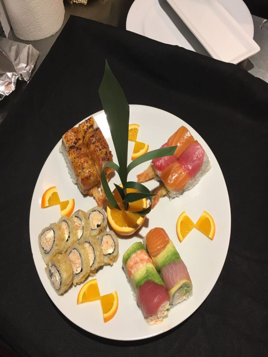 Assorted deluxe sushi platter garnished with orange slices and leaves