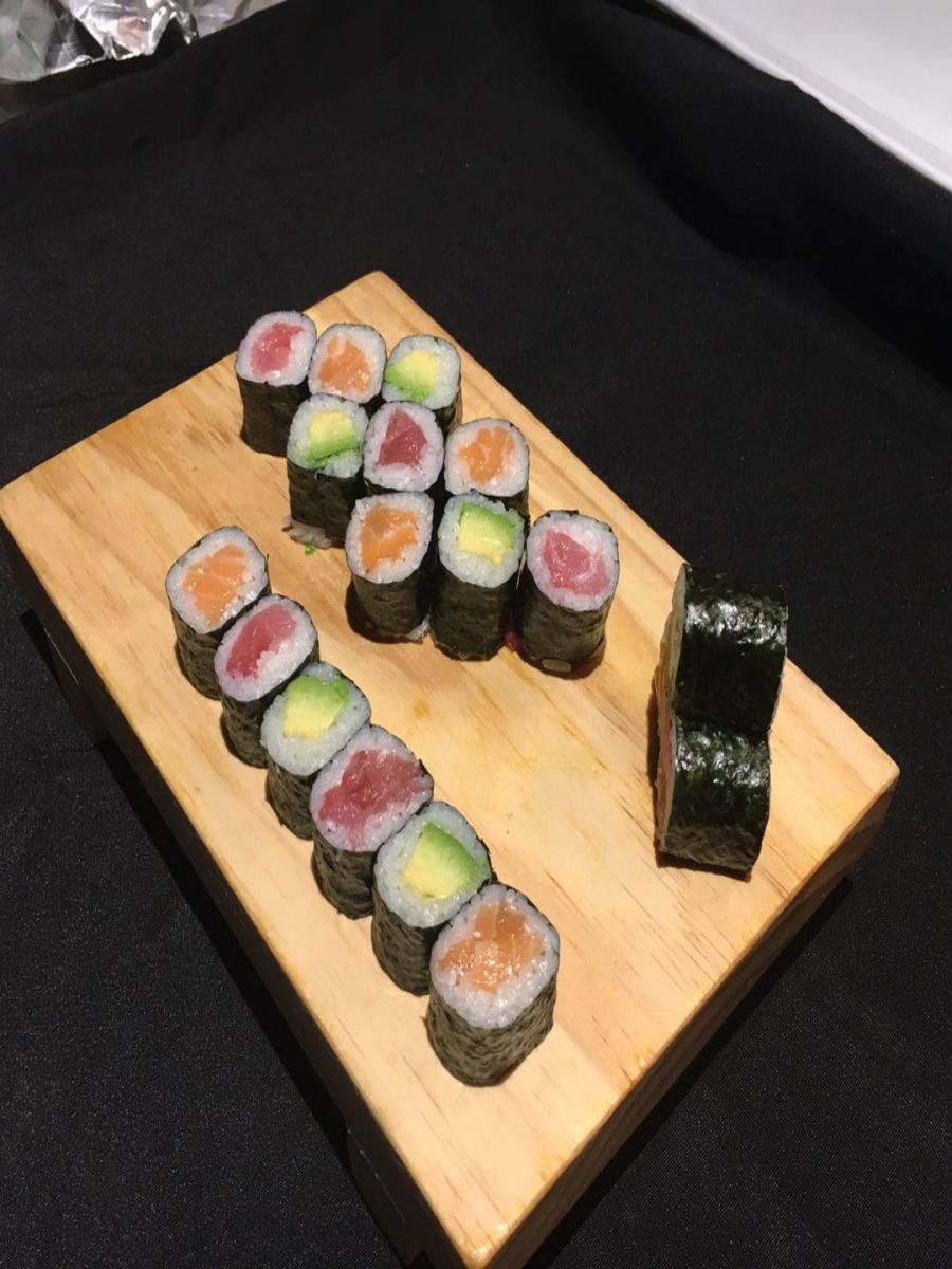 Tuna, salmon and avocado maki rolls on wooden board