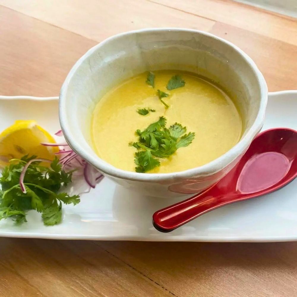 Creamy golden corn soup garnished with fresh cilantro at Sushi of Miso, a Japanese Restaurant in Long Island City.
