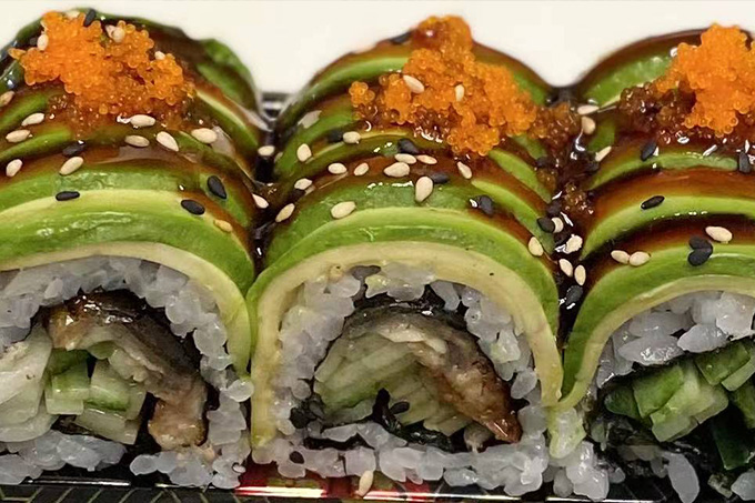 Sushi rolls with layers of avocado, eel and other ingredients, topped with seasoning at SUSHI YA，a Japanese Restaurant in Philadelphia