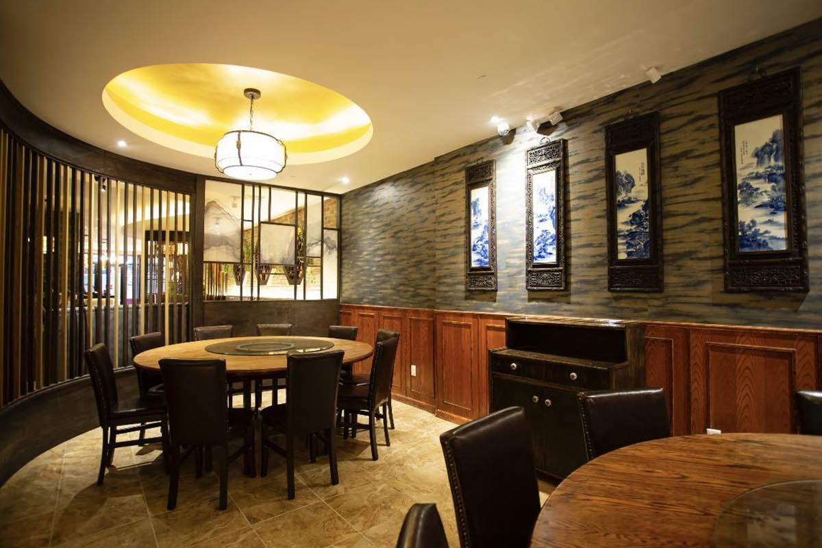 Chinese - style restaurant private room with round table, wooden chairs, and landscape porcelain paintings on the wall at Szechuan Gourmet, a Chinese restaurant in New York