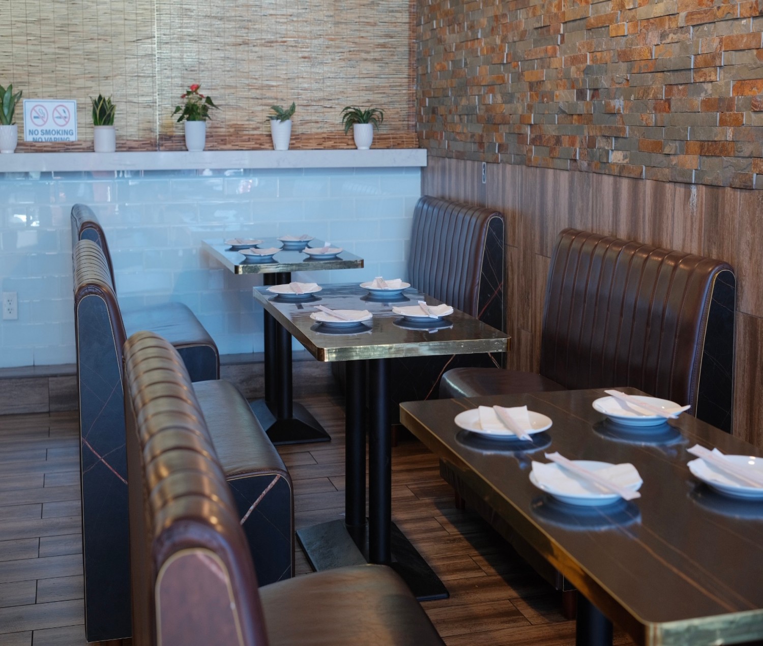 Szechuan-Kitchen-Chinese-Restaurant-Dining-Space-Las-Vegas Neat tables with leather booths, plants and no - smoking sign.