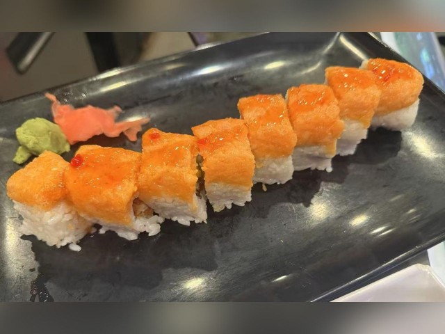 Delicious sushi roll with salmon and rice, served with wasabi and pickled ginger.