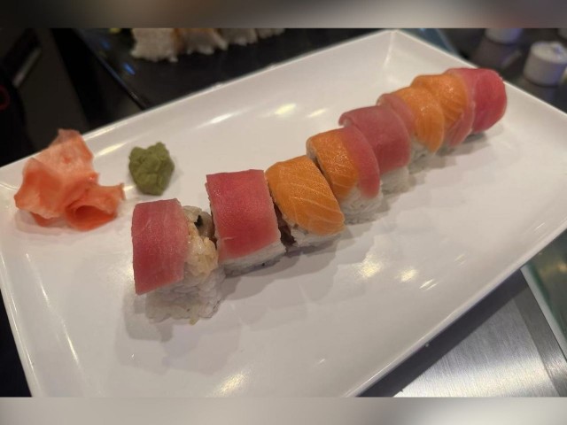 Appetizing sushi roll with tuna, salmon and rice, served with wasabi and pickled ginger.
