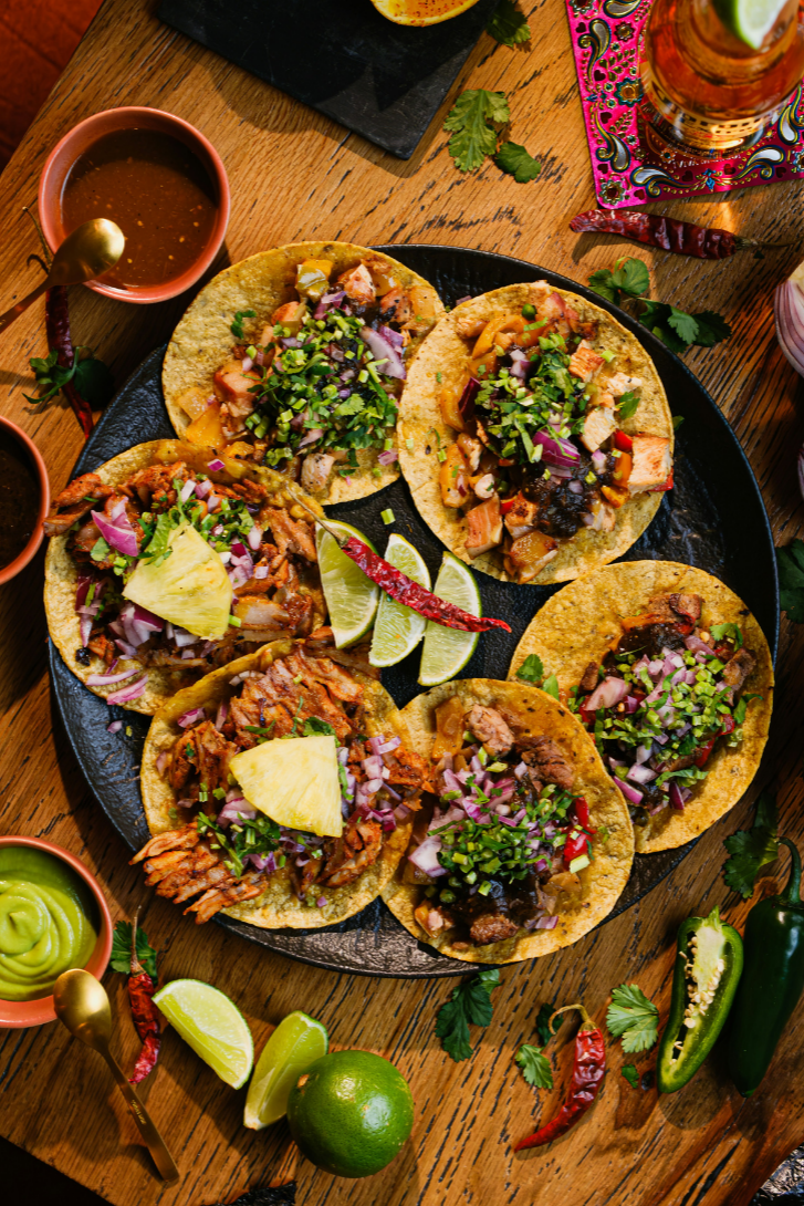 Assorted taco platter with lime and salsas at Taco Vida, a Mexican Restaurant in New York