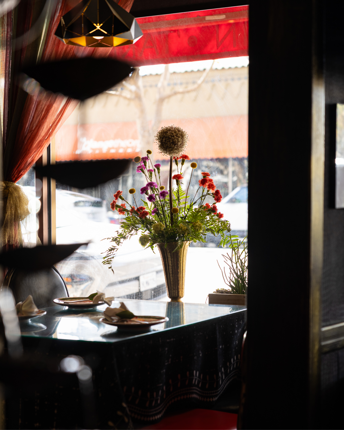 A table by the window with a bouquet of colorful flowers in a vase
