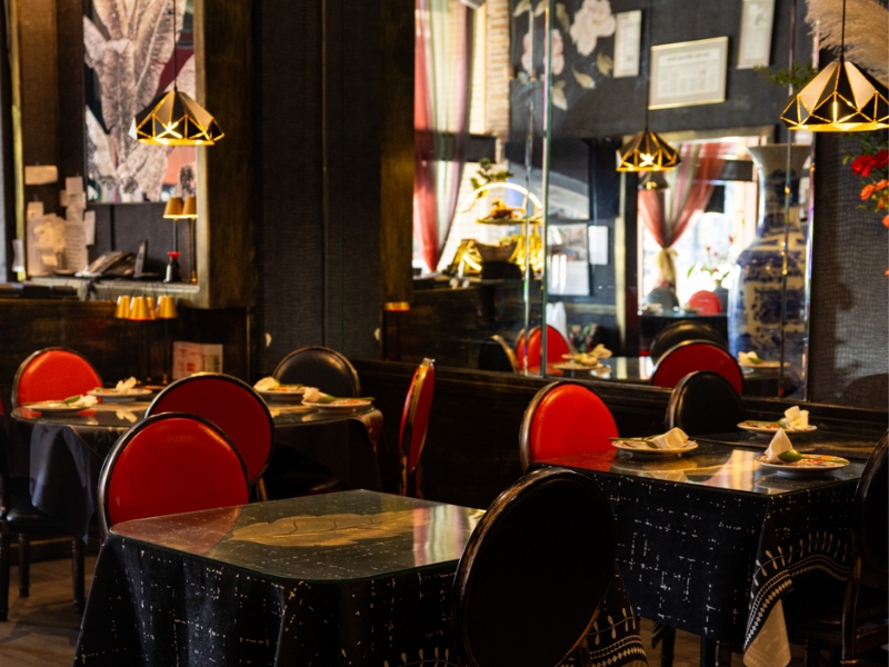 Restaurant dining area with red chairs and stylish pendant lights