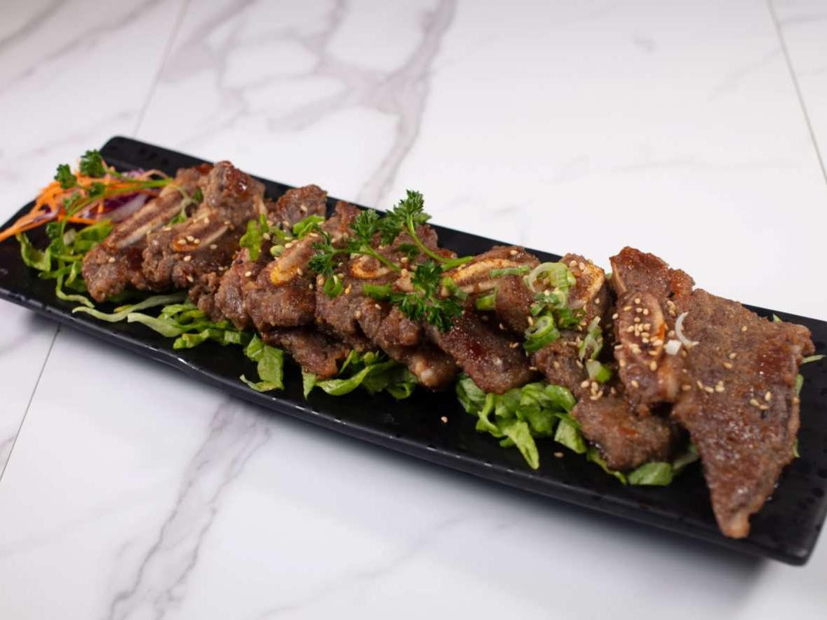 Savory beef ribs with sesame glaze, served over greens at Taki Sushi, a Japanese Restaurant in Toronto