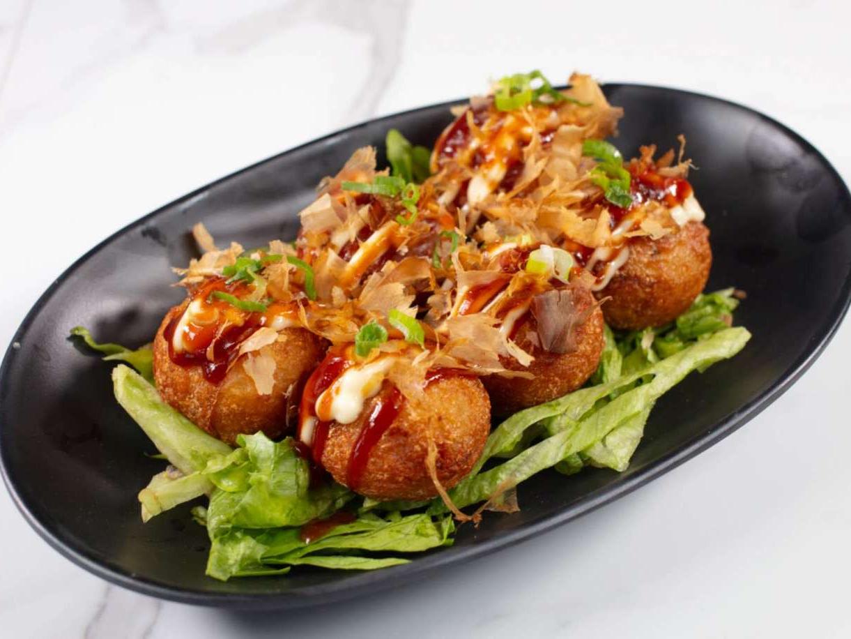 Savory octopus balls topped with sauce, mayo & bonito flakes at Taki Sushi, a Japanese Restaurant in Toronto