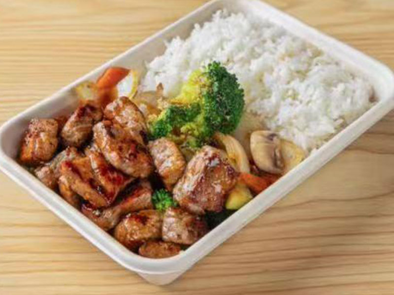 White disposable takeout tray with glazed teriyaki steak bites, mixed veggies and steamed white rice at Takuma Hibachi , a Japanese Restaurant in Hillsboro