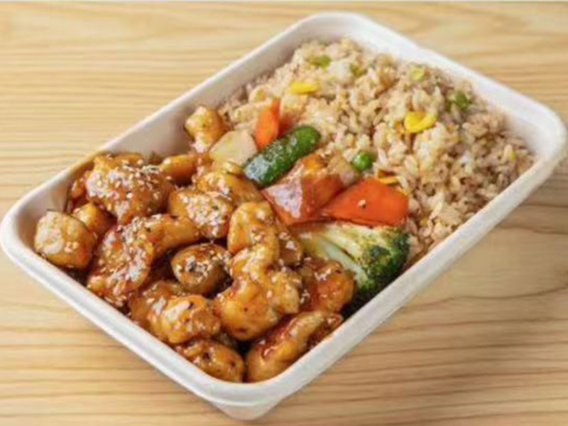 Disposable takeout container with sesame honey glazed chicken stir fry paired with veggie fried rice at Takuma Hibachi , a Japanese Restaurant in Hillsboro