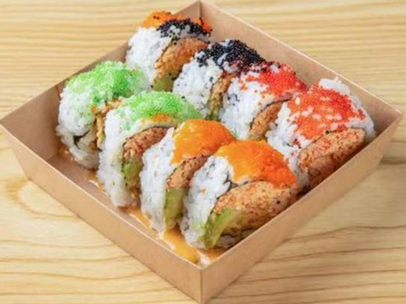 Brown paper takeout box of colorful specialty sushi rolls topped with assorted fish roe at Takuma Hibachi , a Japanese Restaurant in Hillsboro