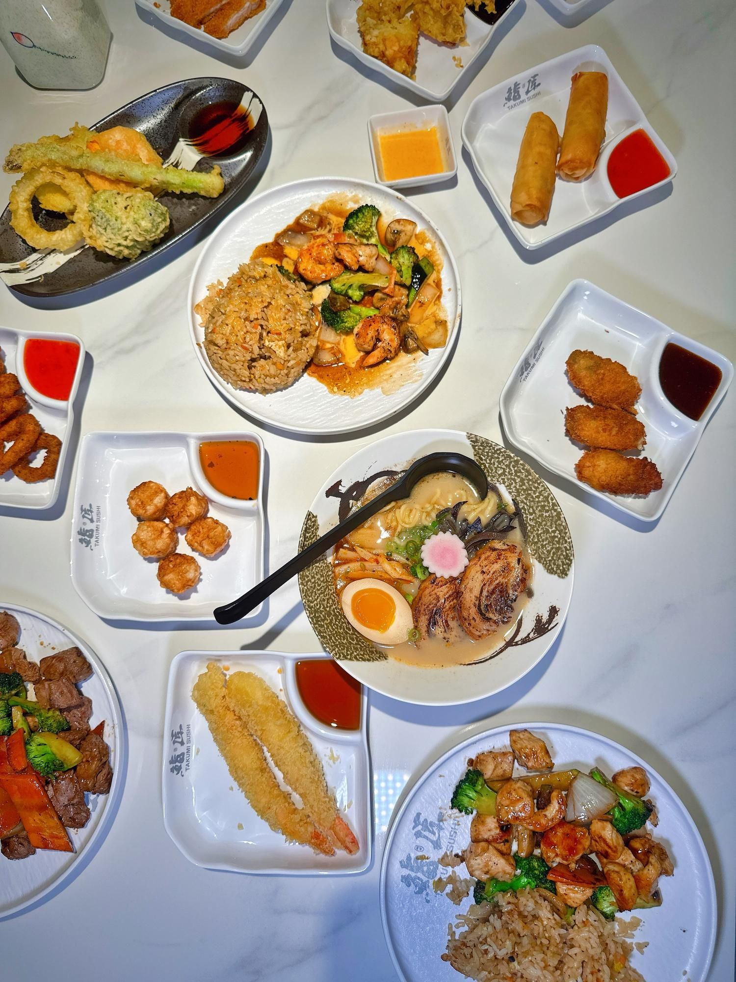 A collection of delicious foods, including ramen, tempura, grilled chicken wings, shrimp balls, and more at Takumi Sushi A.Y.C.E, a Japanese Restaurant in Columbus