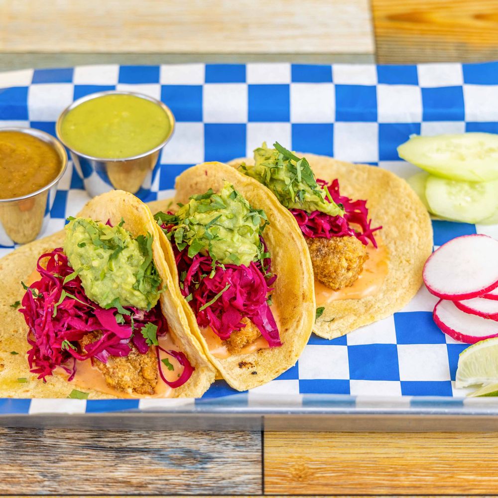 Fish tacos topped with guacamole, pickled red cabbage and cilantro Fish tacos topped with guacamole, pickled red cabbage and cilantro