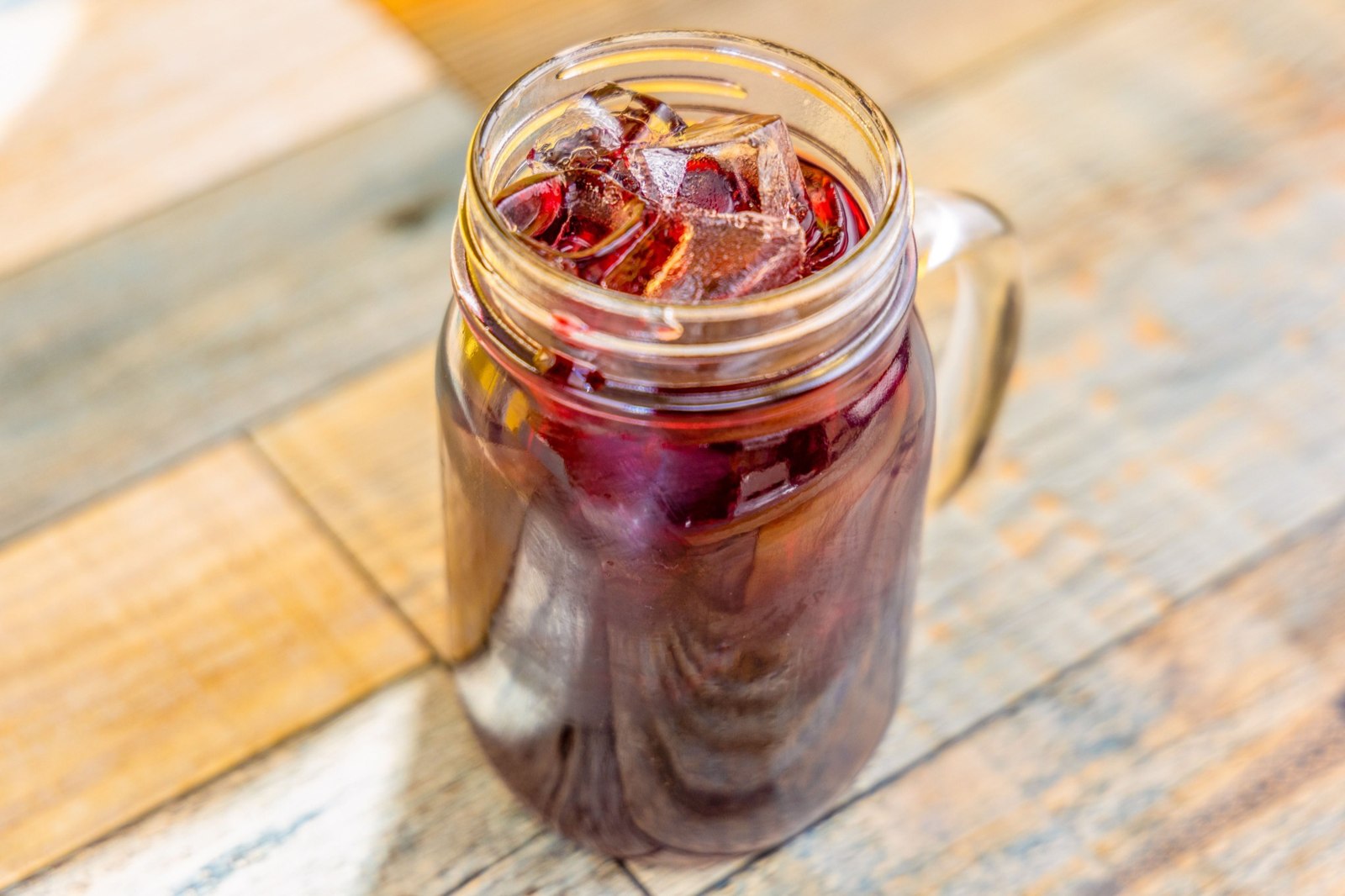 Refreshing agua de jamaica with ice served in a mason jar