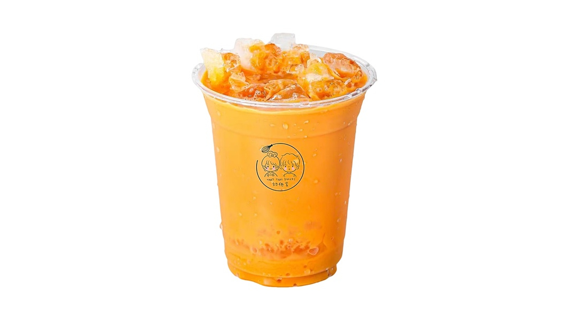 A clear plastic cup showing a vibrant orange Thai iced tea topped with crushed ice cubes, featuring a round logo with cartoon faces on the side, isolated on a white background at Tart Tart Bakery, a Cake shop in Hicksville