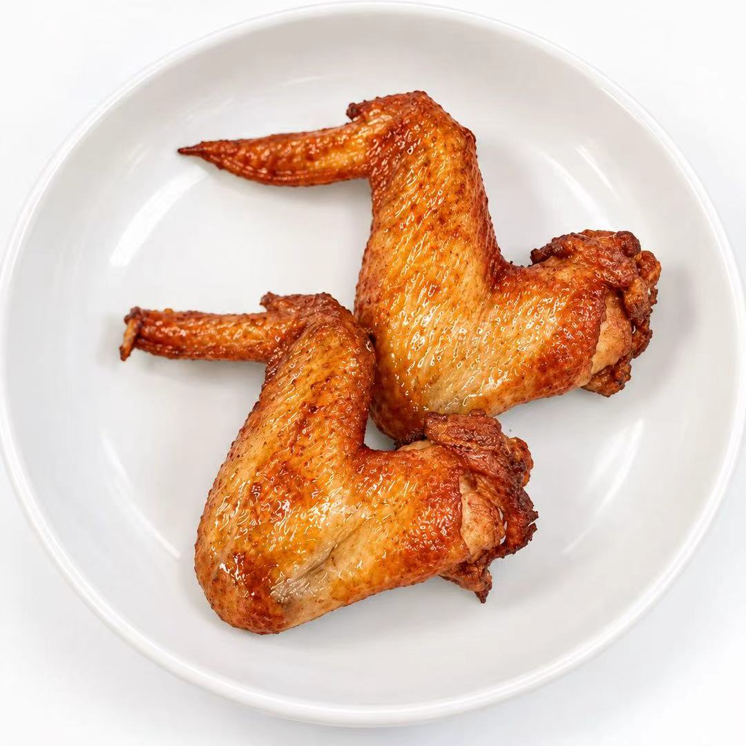 Two roasted chicken wings with glossy brown skin