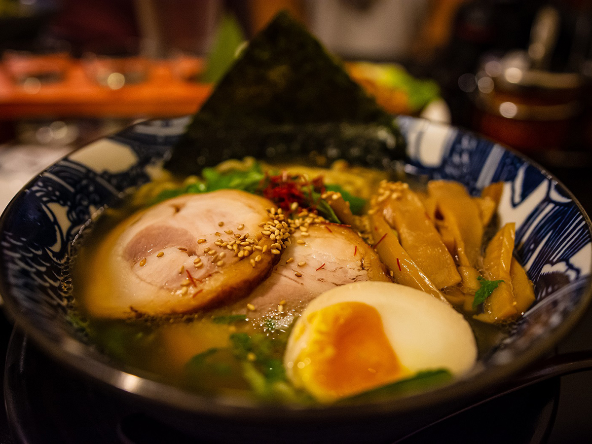 A bowl of Japanese shoyu pork ramen with tender chashu pork, soft-boiled egg, spinach, bamboo shoots, and seaweed in a savory soy-based broth at Tea-aki，a Asian Restaurant in Lewes