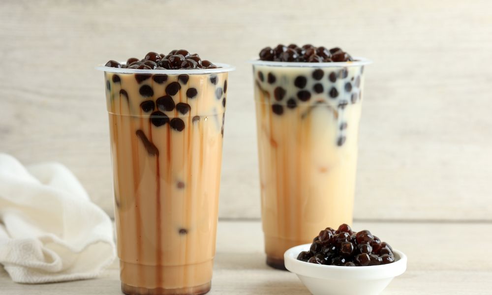 Two brown sugar bubble teas with tapioca pearls in plastic cups at Tea & Brown - Yellowstone, a Bubble Tea Store in West Yellowstone