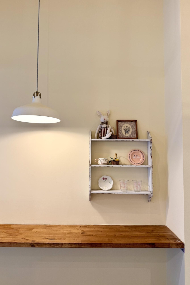 Vintage white wall shelf with bunny doll decor at Tea.Lab, a Bubble Tea Store in FL