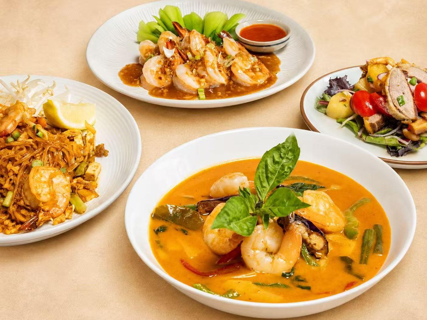 A spread of Thai dishes including curry and stir-fries at Thai Society, a Thai Restaurant in Westfield