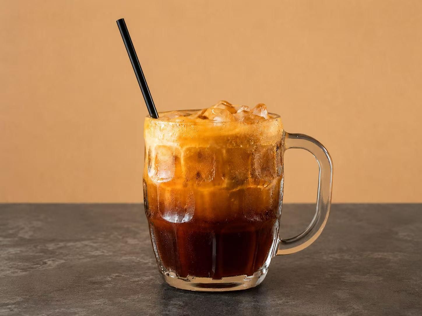 Thai iced tea in a glass mug with a straw at Thai Society, a Thai Restaurant in Westfield
