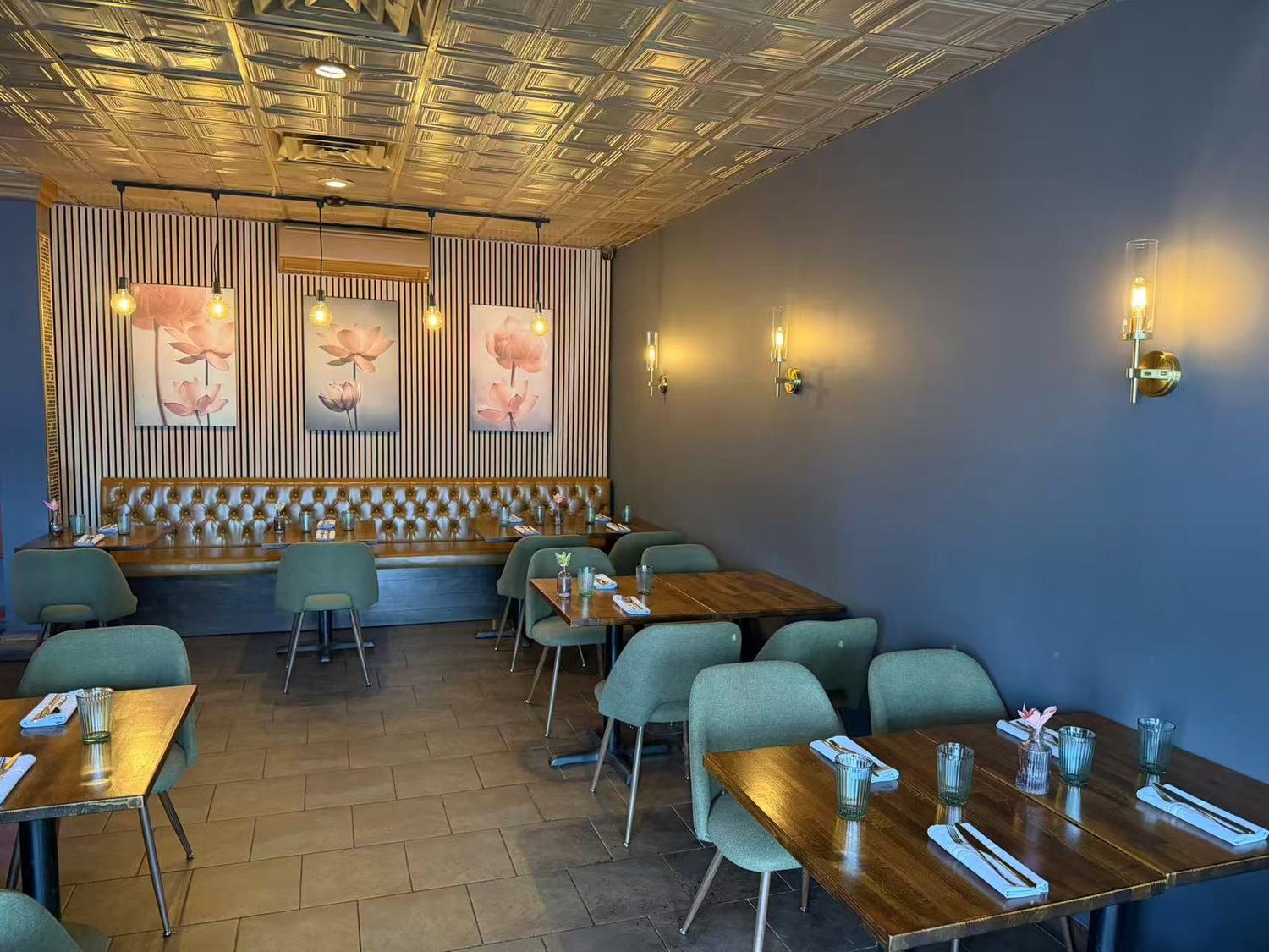Modern restaurant interior with teal chairs, tufted booth, and lotus art at Thai Society, a Thai Restaurant in Westfield