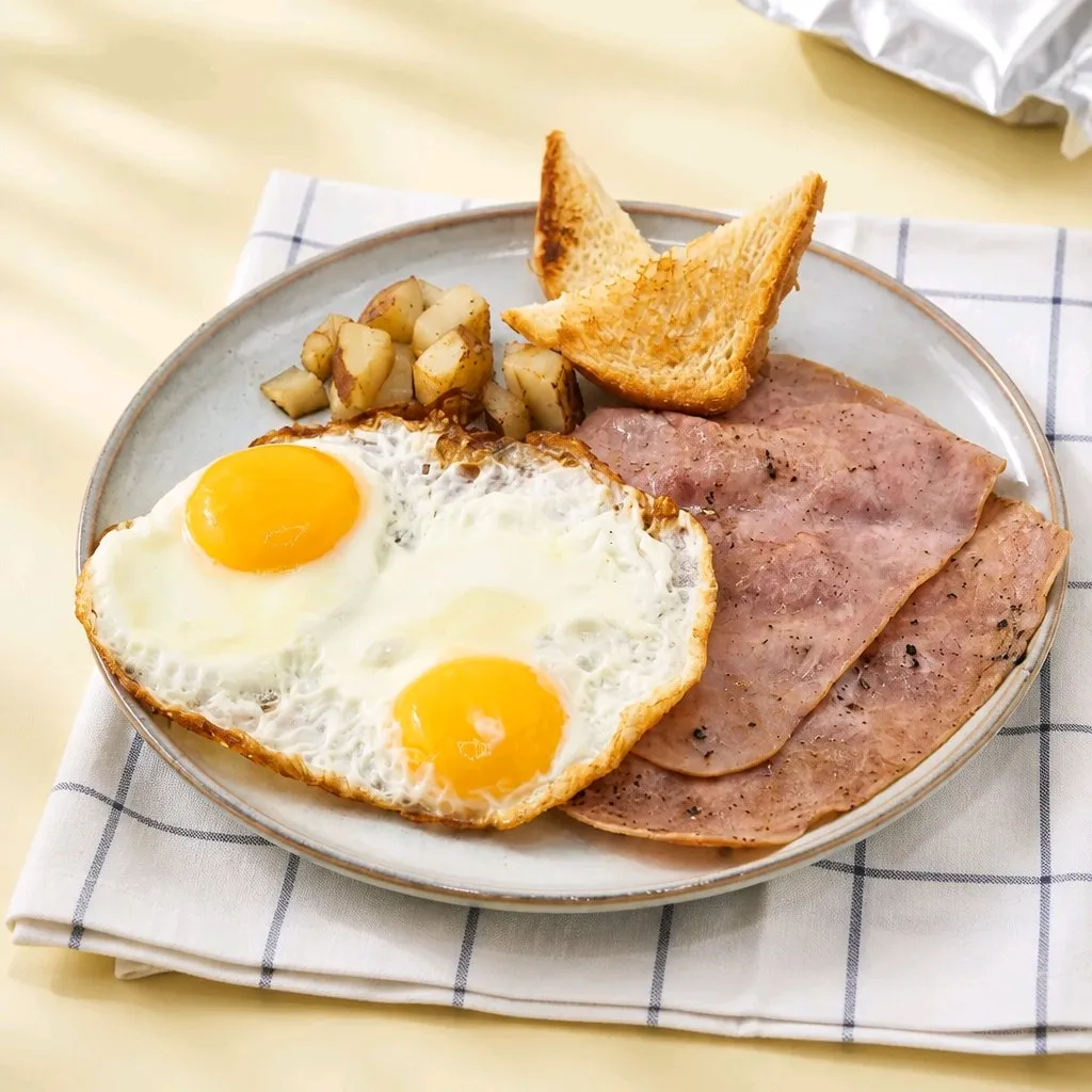 Two sunny eggs, ham slices, toast and roasted potato cubes at The Second Wind, a Breakfast Restaurant in El Segundo