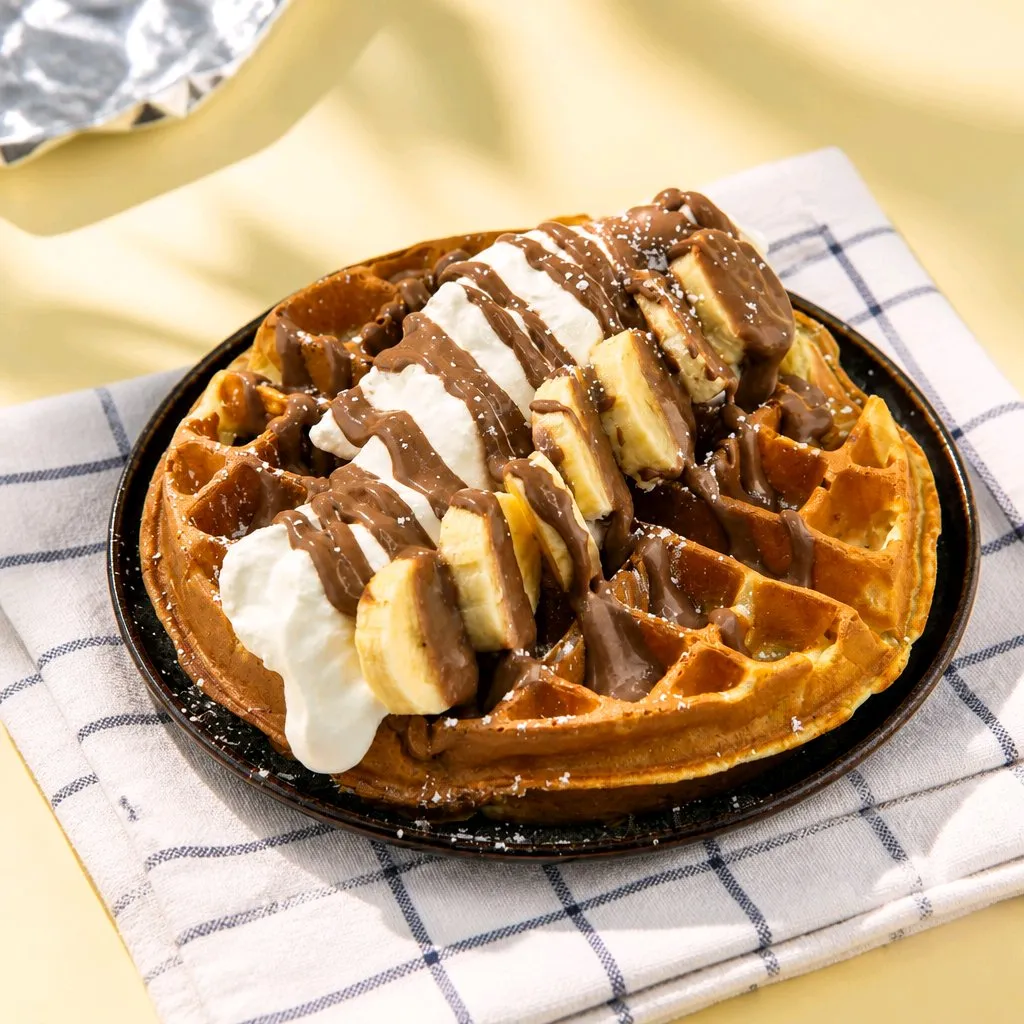 Waffle topped with banana, chocolate sauce and whipped cream at The Second Wind, a Breakfast Restaurant in El Segundo
