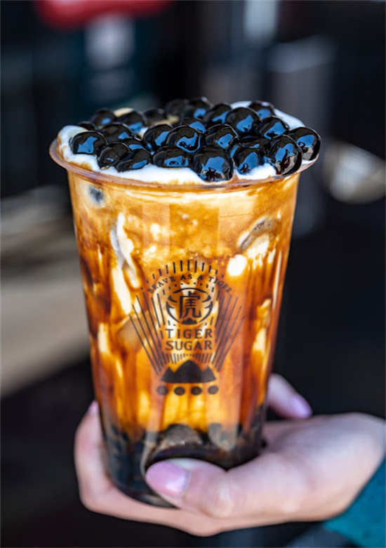 Palm holding tiger sugar signature brown sugar bubble tea cup at Tiger Sugar, a Bubble tea store in Philadelphia