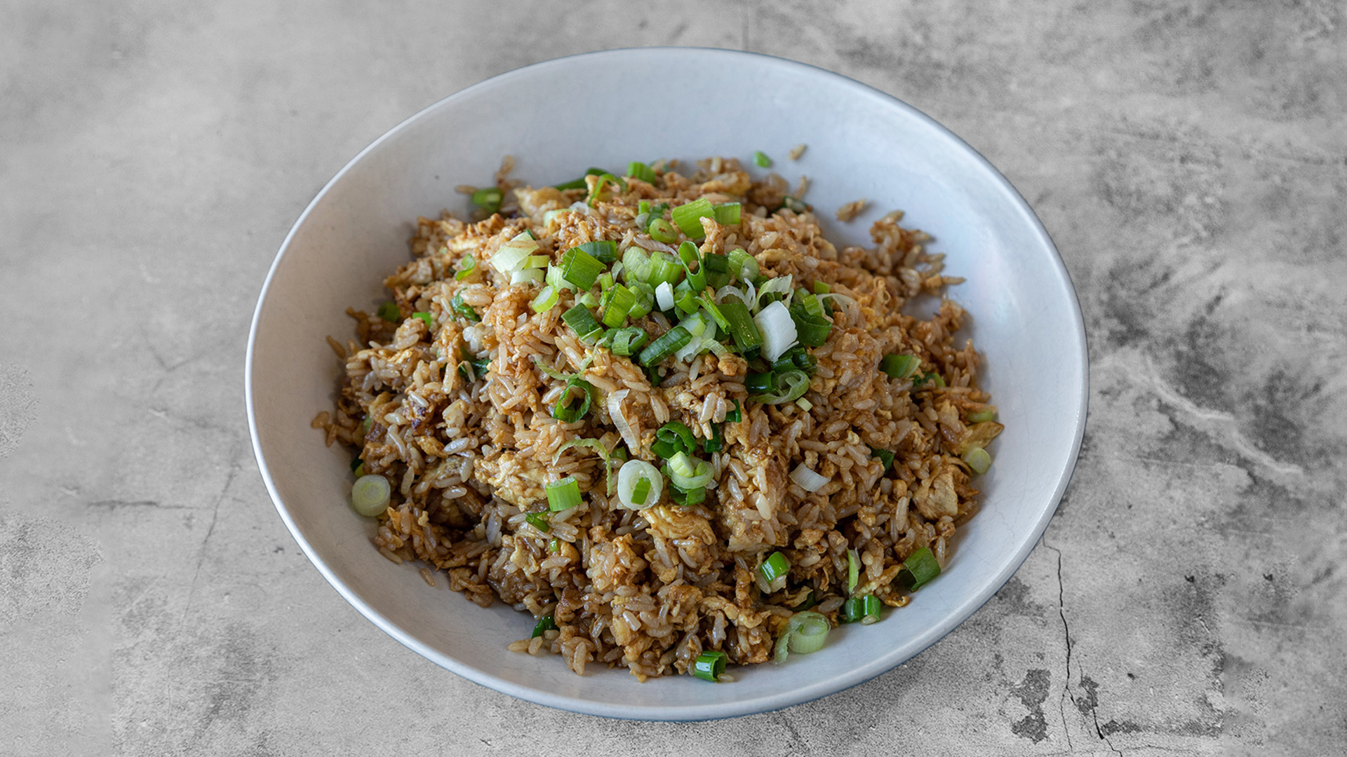 Plain egg fried rice mixed with scrambled egg and finely chopped green onions served in matte white wide bowl at Mandarin Chinese & Japanese Cuisine , a Chinese Restaurant in Santa Monica