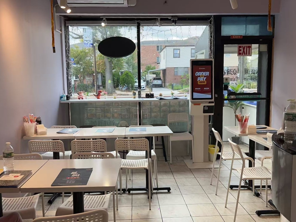 Bright dining area with large windows, self-order kiosk, and white furniture at Ti Hu Taiwanese Noodle House, a Chinese Restaurant in Bayside