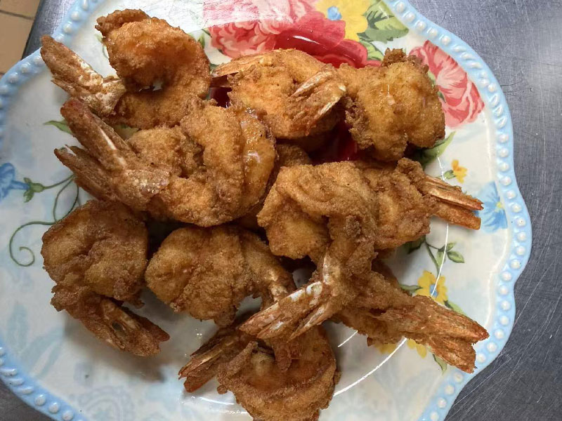 Crispy breaded fried shrimp served on a decorative floral plate at Tiktok Wings, a Fast Food Restaurant in Syracuse