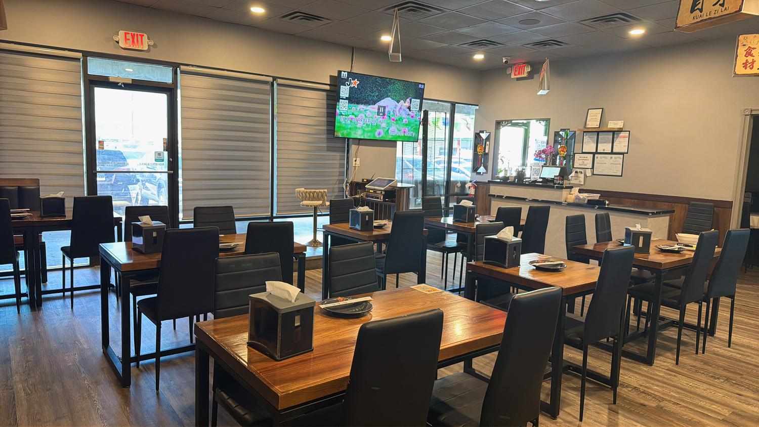 Restaurant entrance and dining area with a TV at Tipsy Nine，a Asian Fusion Restaurant in Houston