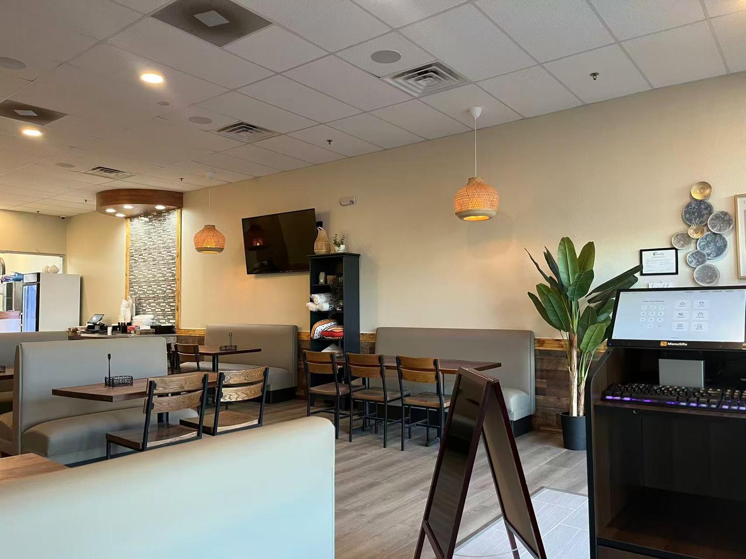 Cozy dining area with booths, tables and decorative plants at Tokyo Cafe Sushi and Asian Food, a Asian Fusion Restaurant in Lubbock
