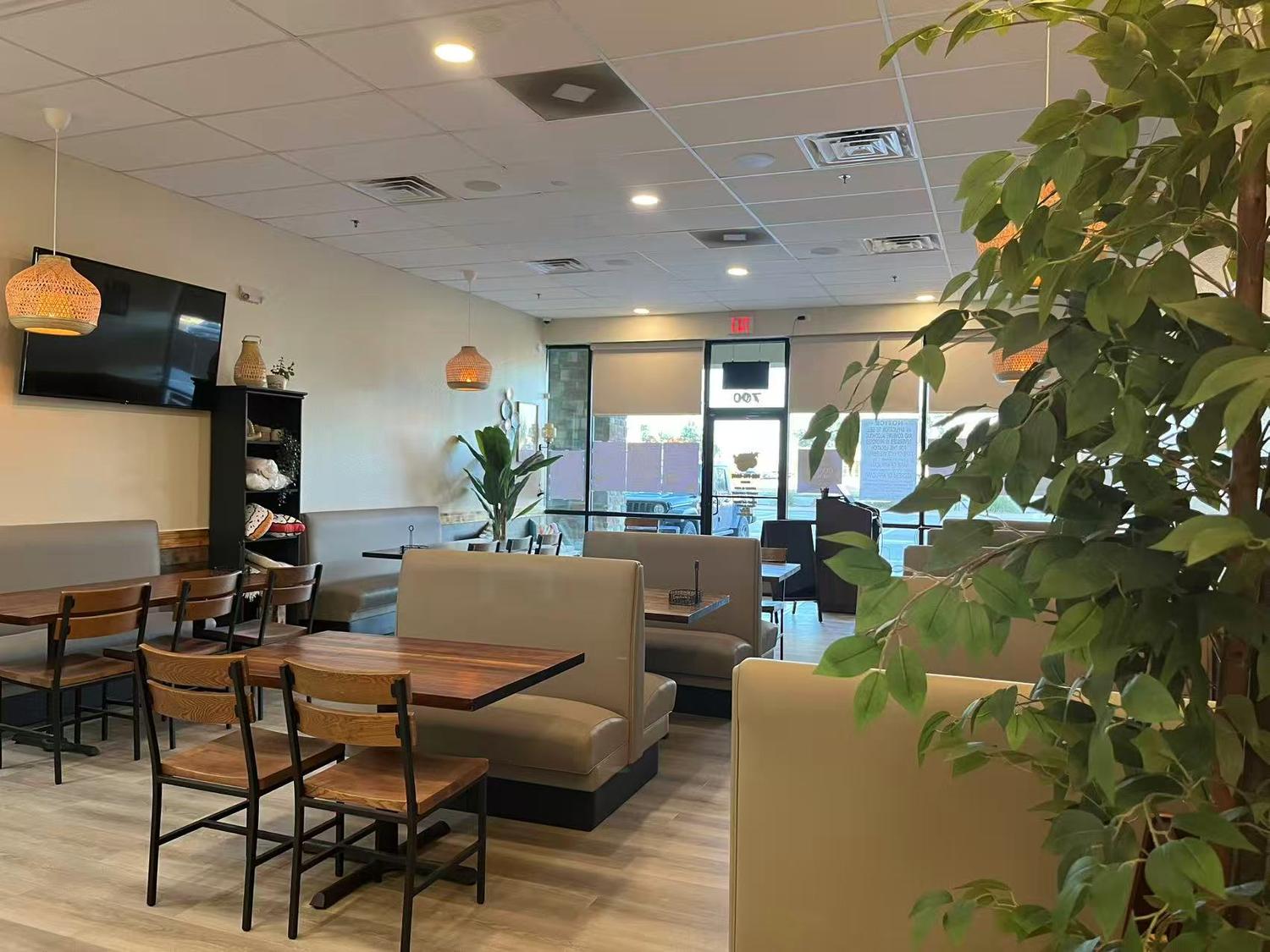 Bright dining area with wooden tables, booths and hanging lamps at Tokyo Cafe Sushi and Asian Food, a Asian Fusion Restaurant in Lubbock