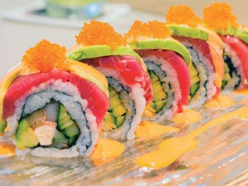 Gourmet sushi roll with tuna, avocado, crab, and tobiko, drizzled with sauce at Golden City Tokyo Sushi & Hibachi, a Japanese Restaurant in Terryville