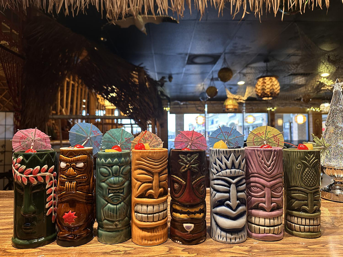 Colorful tiki mugs with tropical drinks and umbrellas at Tong's Tiki Hut, an Asian Fusion Restaurant in Villa Park