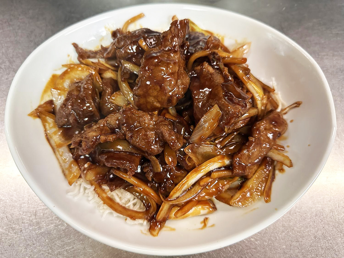 Braised beef and onions over rice at Tong's Tiki Hut, an Asian Fusion Restaurant in Villa Park