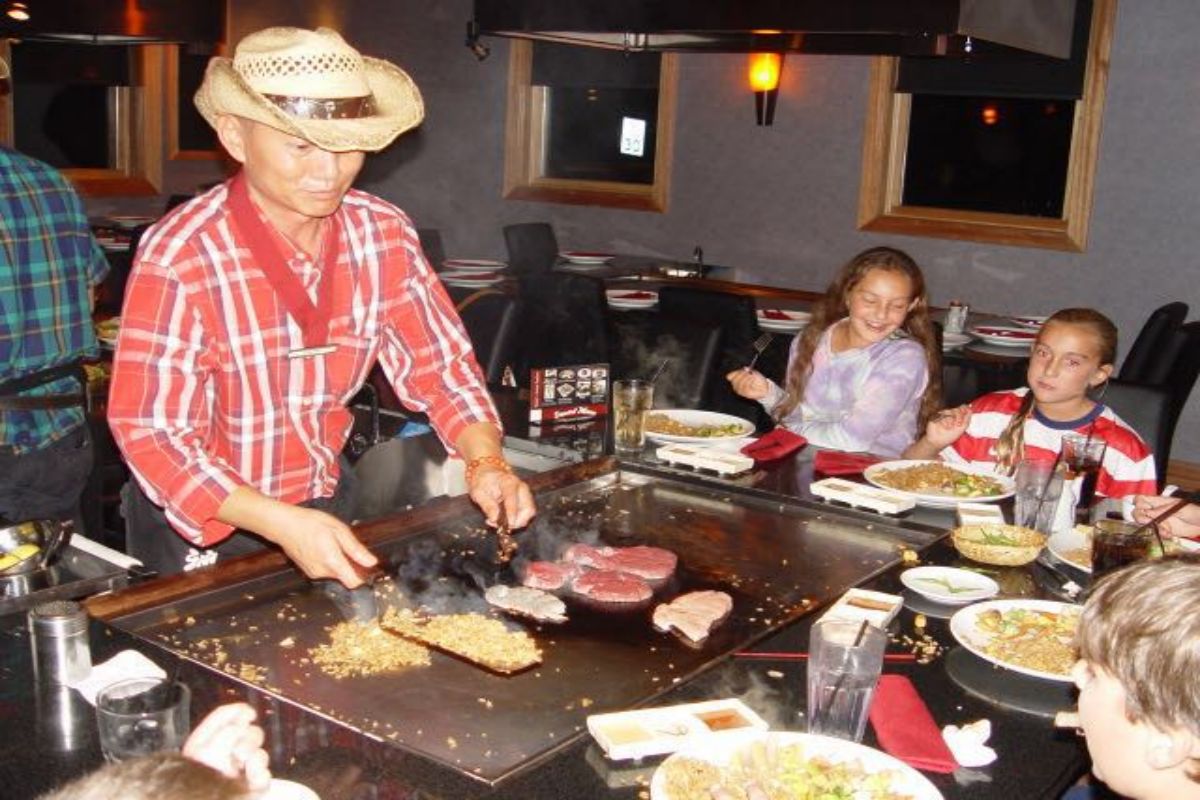 Chef cooks steak and fried rice on hot teppanyaki grill at Tony's Sushi & Steakhouse, a Japanese Restaurant in East Moriches