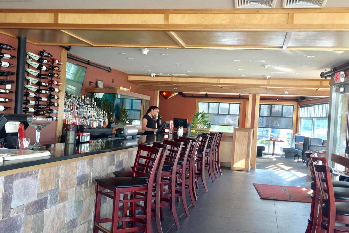 Female staff working behind stone-faced bar counter at Tony's Sushi & Steakhouse, a Japanese Restaurant in East Moriches
