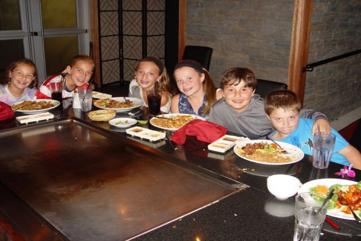 Group of kids posing with teppanyaki meal plates at Tony's Sushi & Steakhouse, a Japanese Restaurant in East Moriches