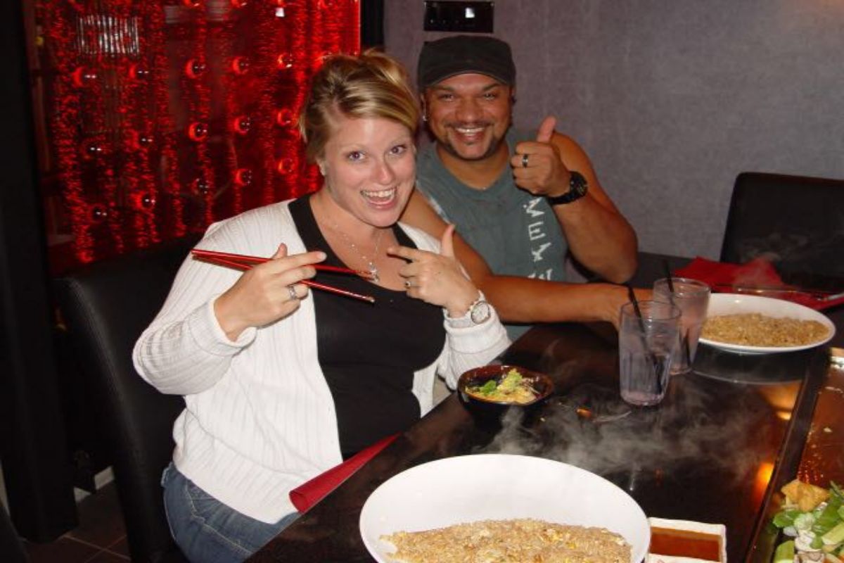 Smiling couple posing with chopsticks at teppanyaki table at Tony's Sushi & Steakhouse, a Japanese Restaurant in East Moriches