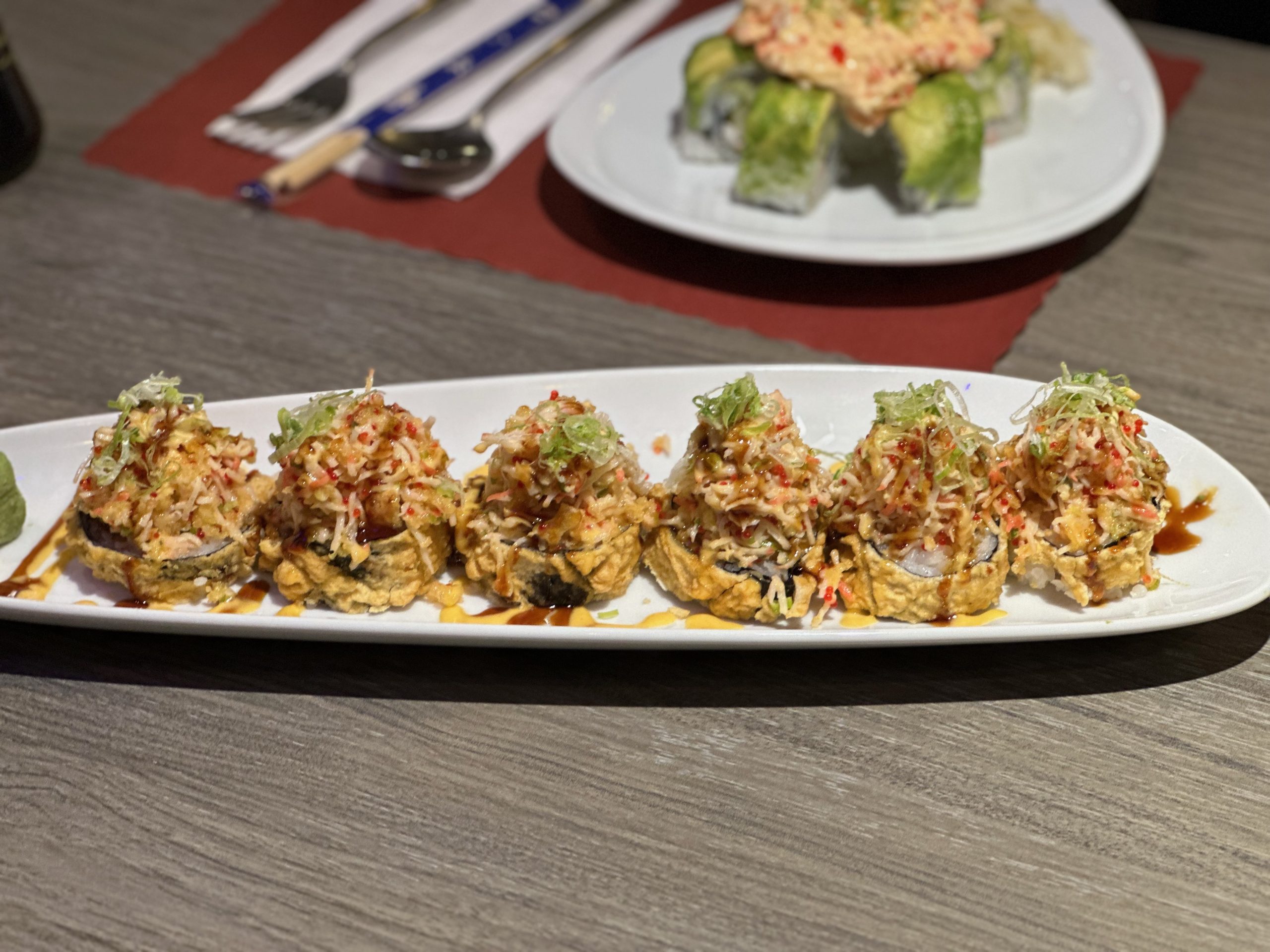 Crispy sushi pieces topped with shredded crab, greens, and sauces at Tora Sushi, a Asian Fusion Restaurant in Media